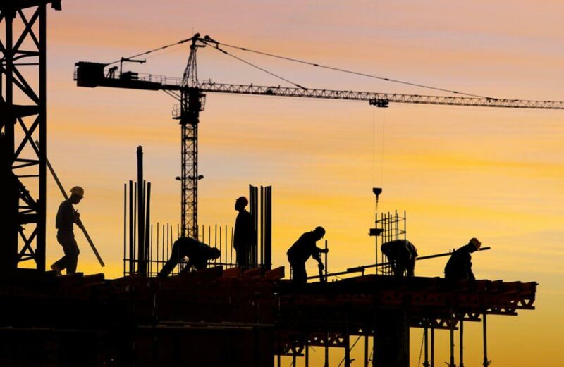 Workers at height at sunset